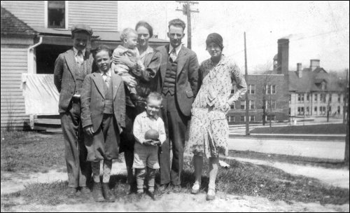 Left to right: Herschell, Floyd, Dale, Mom, Dad, Naomi, Ray (in front). This must be in Petoskey, Michigan, in about 1928.