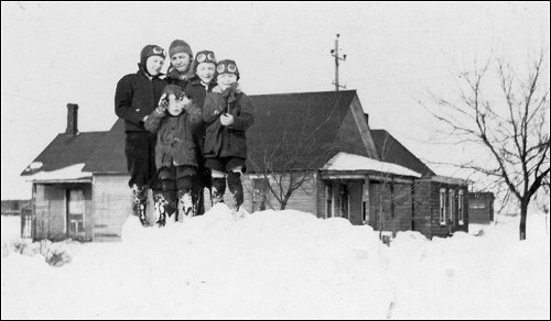 Ray, someone, Dale, Jess, and Don down in front. First house in Cadillac. 1935?